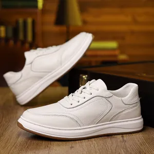 Detailed view of white genuine leather men's sneakers with premium texture and laces.