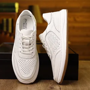 Detailed view of white genuine leather men's sneakers with breathable perforated design