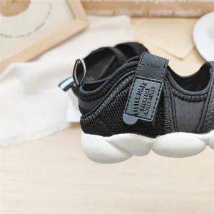 Close-up detail of black breathable mesh children's sports sandals with white chunky sole