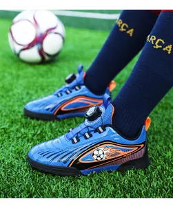 Scarpe da calcio per bambini blu con sistema di chiusura a rotella su prato verde