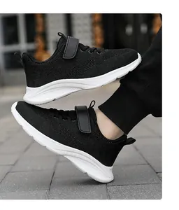 Vista detallada de zapatillas de malla negra para niños con suela blanca y velcro