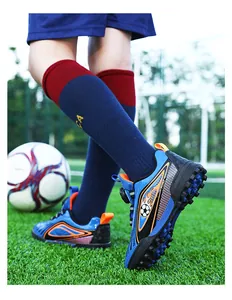 Scarpe da calcio blu per bambini con tacchetti su campo in erba