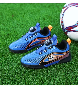 Dettaglio scarpe da calcio blu per bambini con sistema a fibbia rotante su erba.
