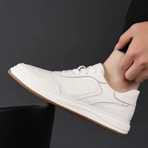Detailed side view of a white genuine leather sneaker with minimalist stitching