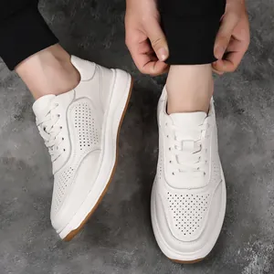 Close-up detail of men's white cowhide leather sneakers with perforated design.