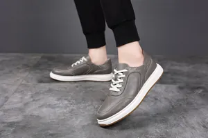 Detail view of grey pebbled leather sneakers for men with white sole and laces