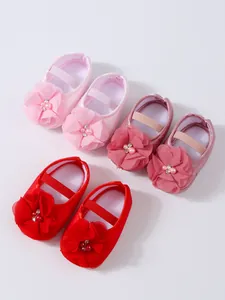 Vue détaillée de chaussures de princesse souples pour bébé en rose et rouge avec fleurs