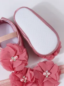 Vue détaillée de chaussures de princesse roses avec fleurs, perles et semelle antidérapante.