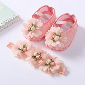 Detailed view of soft-soled pink infant princess shoes with matching flower headband set