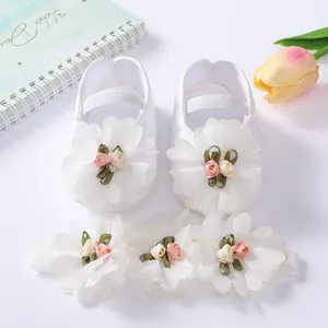 Detailed view of soft-sole white baby princess shoes and matching floral headband set