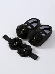 Vue détaillée des chaussures de princesse pour bébé avec un bandeau à fleurs assorti