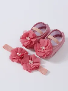 Vue détaillée de chaussures de princesse roses pour bébé avec bandeau floral assorti