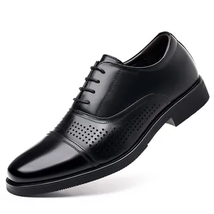 Black men's formal leather dress shoes with decorative brogue perforations in a macro view