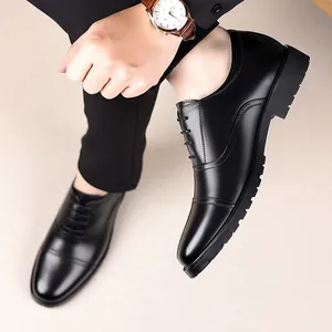 Elegant close-up view of men's black genuine leather cap-toe dress shoes for formal business