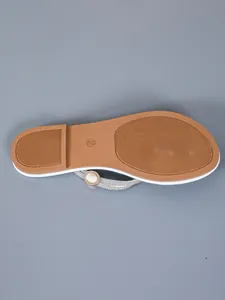 Detailed macro view of the anti-slip brown sole on rhinestone flat flip-flop sandals