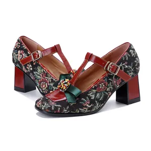 Detailed view of vintage Mary Jane heels featuring floral tapestry and a colorful beaded bow