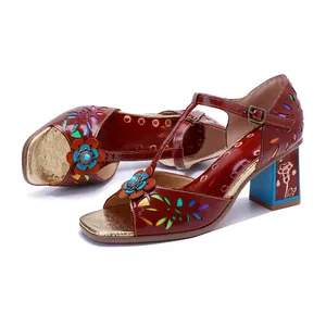 Nahaufnahme der Vintage-Ledersandalen mit bunten floralen Mustern und blauem Blockabsatz.