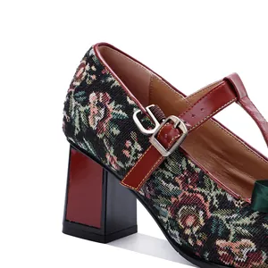Detail shot showing vintage floral tapestry Mary Jane shoe with red T-strap and buckle.
