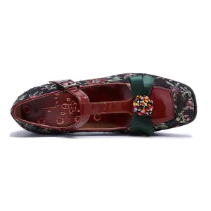 Top view detail of vintage Mary Jane shoe with floral tapestry and green bow accent