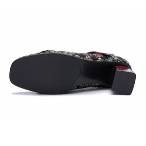 Detailed view of the square chunky heel and smooth black sole of vintage floral Mary Jane pumps.