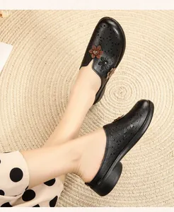 Elegant black closed-toe mules with laser-cut floral patterns and non-slip soft sole