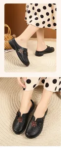 Detailed view of black hollowed-out floral mules with non-slip flat soles for women.