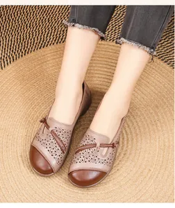 Macro view of breathable hollow-out leather loafers for women with knotted detail