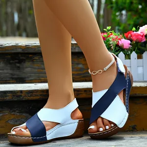 Close-up detail of blue and white cross-strap wedge sandals worn on wooden stairs
