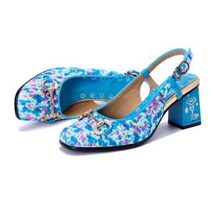 Detalle de zapatos slingback de pelo de poni floral con bocado de metal decorativo