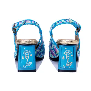 Vista trasera de sandalias azules de tacón grueso con grabado floral y pelo