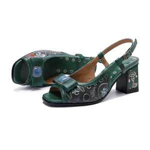 Vue détaillée de sandales en cuir vert fait main à talons carrés et relief floral 3D.