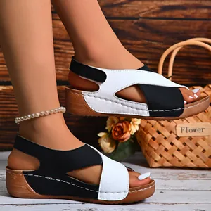 Detailed view of women's stylish black and white cross-strap wedge sandals for summer beach wear.