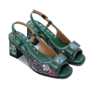 Vue détaillée de sandales en cuir vert faites main avec motifs floraux gaufrés chic
