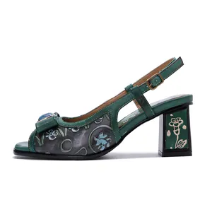 Détail latéral de sandales vertes en cuir frotté à la main avec un relief floral