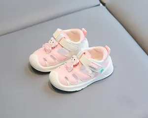 Detail view of pink and white baby toddler sandals featuring a cute bear and soft sole
