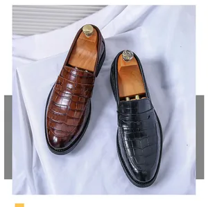 Top view detail of premium brown and black crocodile embossed leather penny loafers for men