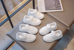 High-quality kids' breathable white mesh sneakers with Velcro straps shown on a bench.
