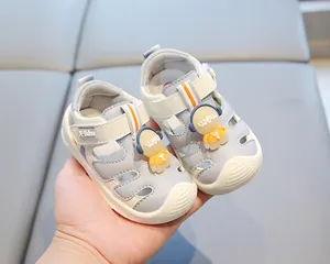 Detail of grey baby closed-toe beach sandals with cute cartoon astronaut decoration