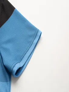 Detailopname van blauwe wafelgebreide textuur en stiksels op een heren polo met korte mouwen