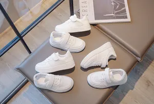 Detailed view of breathable white mesh sneakers for kids with hook and loop straps.