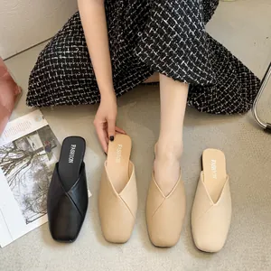 Dettaglio di eleganti sabot bassi con scollo a V in nero e beige, collezione primavera 2025.