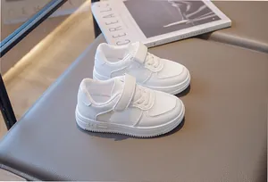 Detailed view of children's white mesh sneakers with breathable texture and velcro strap
