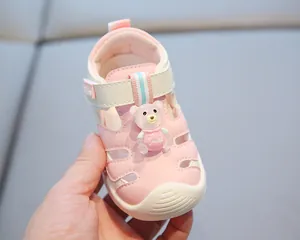 Adorable pink closed-toe toddler sandal featuring a cute bear figurine and soft sole
