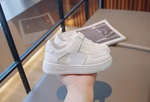 Close-up of breathable mesh and velcro strap on kids' white sneakers for summer