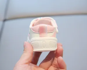 Macro detail of the reinforced soft heel on pink and white closed-toe baby walking sandals