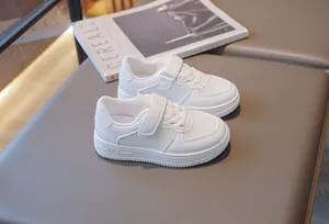 Close-up of white breathable mesh sneakers for kids with Velcro straps.