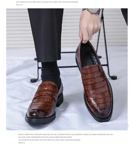 Detailed view of brown embossed crocodile leather loafers for men.