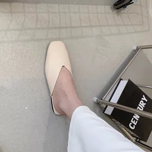 Dettaglio di sabot flat alla moda color crema a punta quadrata con design a V unico