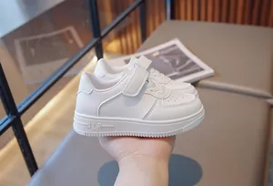 Close-up of white children's velcro sneakers with breathable holes and ALR logo