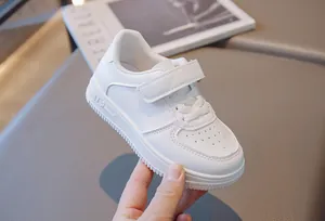Detailed view of white children's sneakers with Velcro straps and breathable toe